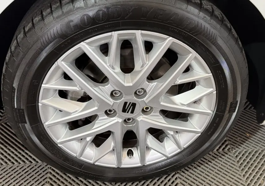 Gros plan sur la jante alu argentée avec logo SEAT d’une SEAT Ibiza blanche, roue équipée de pneus Goodyear.