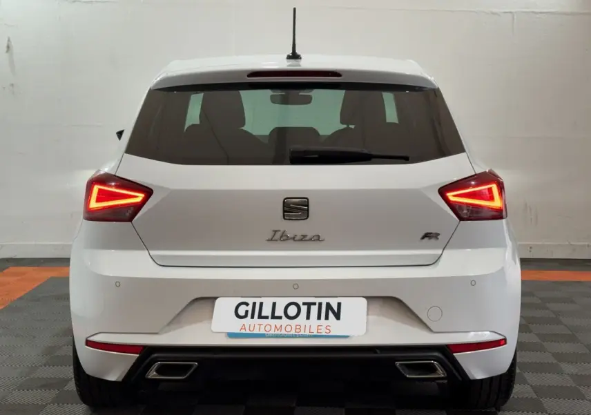 Vue arrière d'une SEAT Ibiza 1.0 TSI 110 FR blanche avec feux LED triangulaires et doubles sorties d'échappement.