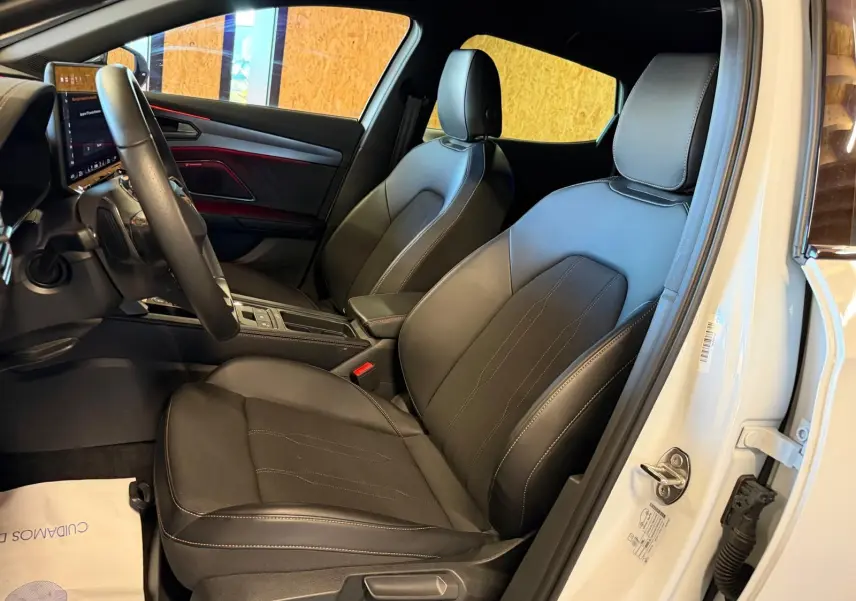 Vue intérieure côté conducteur du CUPRA Formentor blanc 2025, sièges en cuir noir avec surpiqûres blanches et tableau de bord moderne.