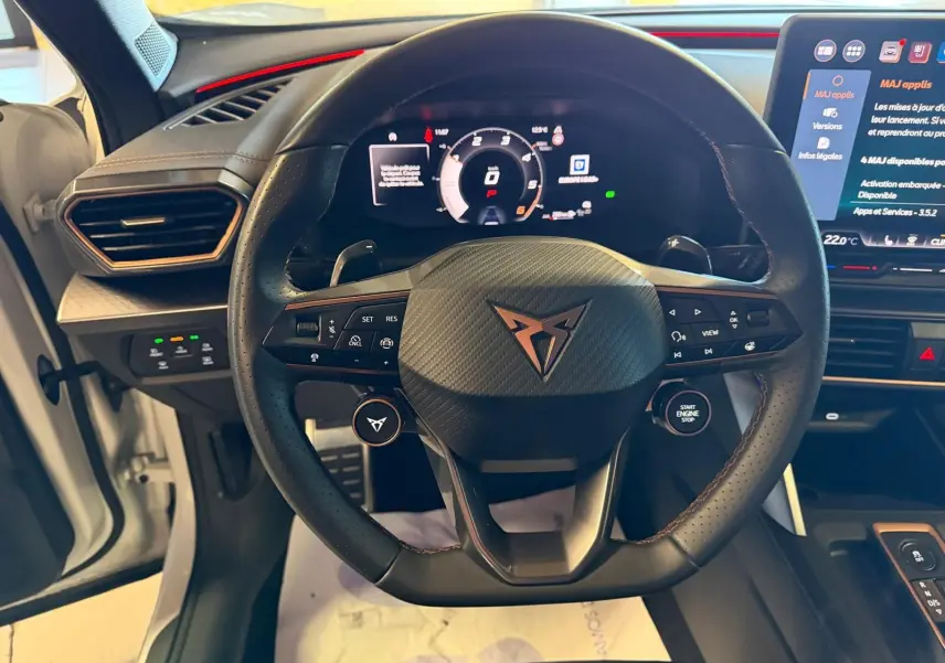 Vue frontale du volant cuir noir perforé avec logo CUPRA, tableau de bord digital et écran tactile du CUPRA Formentor blanc 2025.