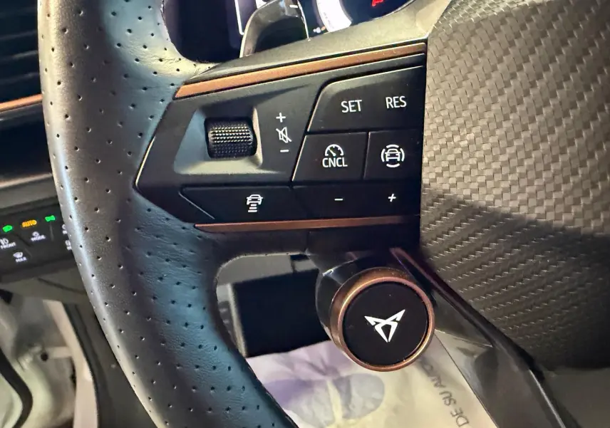 Gros plan sur le volant cuir perforé noir du CUPRA Formentor 2025 avec commandes de régulateur et logo CUPRA central.