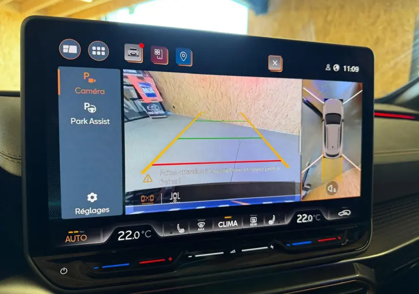 Écran tactile intérieur affichant l'aide au stationnement avec vue caméra et capteurs du CUPRA Formentor blanc.