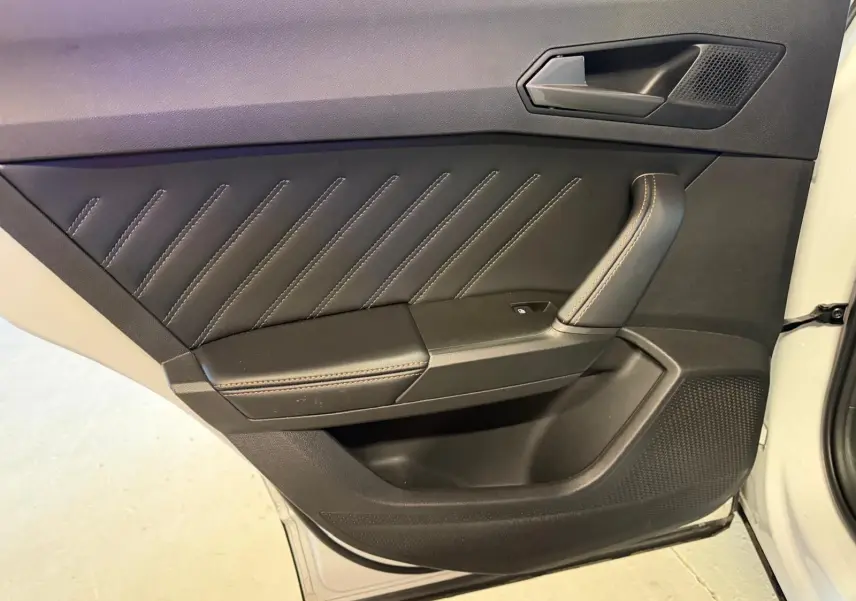 Gros plan sur la porte avant droite blanche du CUPRA Formentor 2025, avec garniture noire et surpiqûres contrastées.