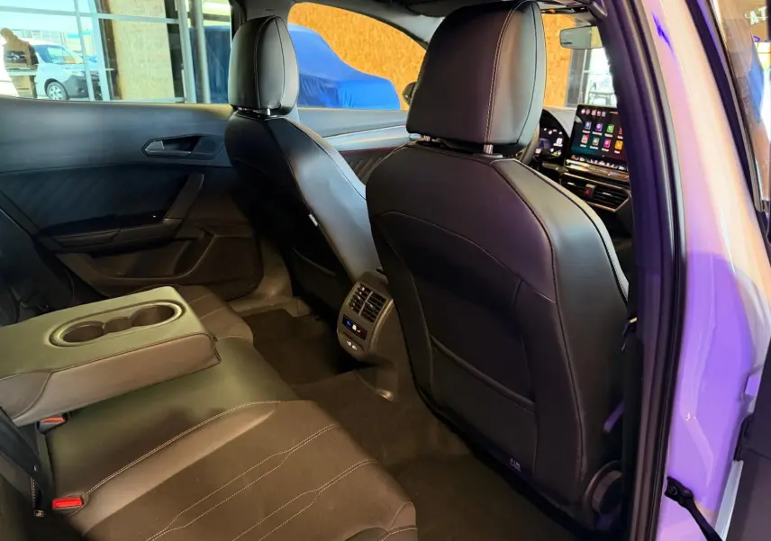 Vue intérieure arrière droite de la CUPRA Formentor 2025 blanche, montrant les sièges en cuir noir et l'accoudoir central rabattable.