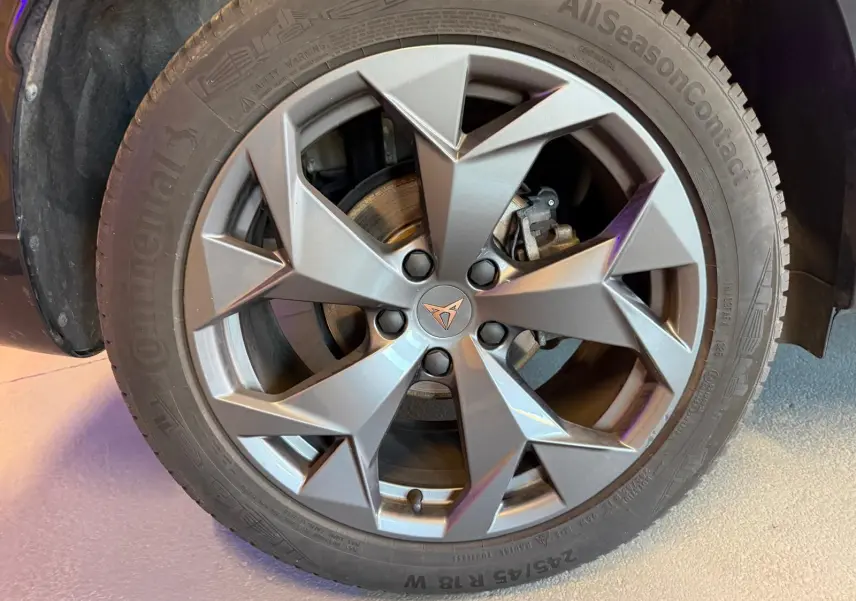 Gros plan sur la jante alliage grise à design géométrique du CUPRA Formentor blanc, avec logo CUPRA au centre.