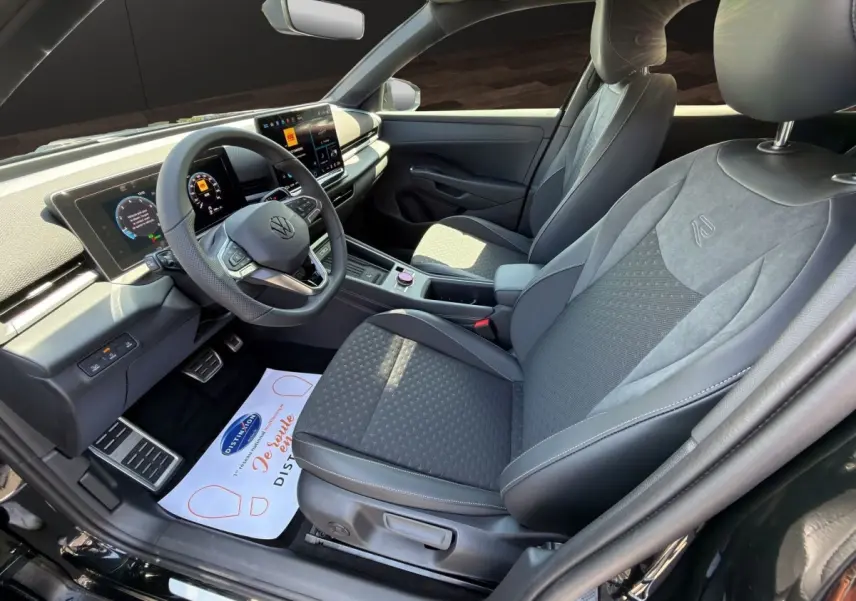 Vue intérieure côté conducteur du Volkswagen T-Roc noir 2026, avec sièges R-Line et tableau de bord digital.