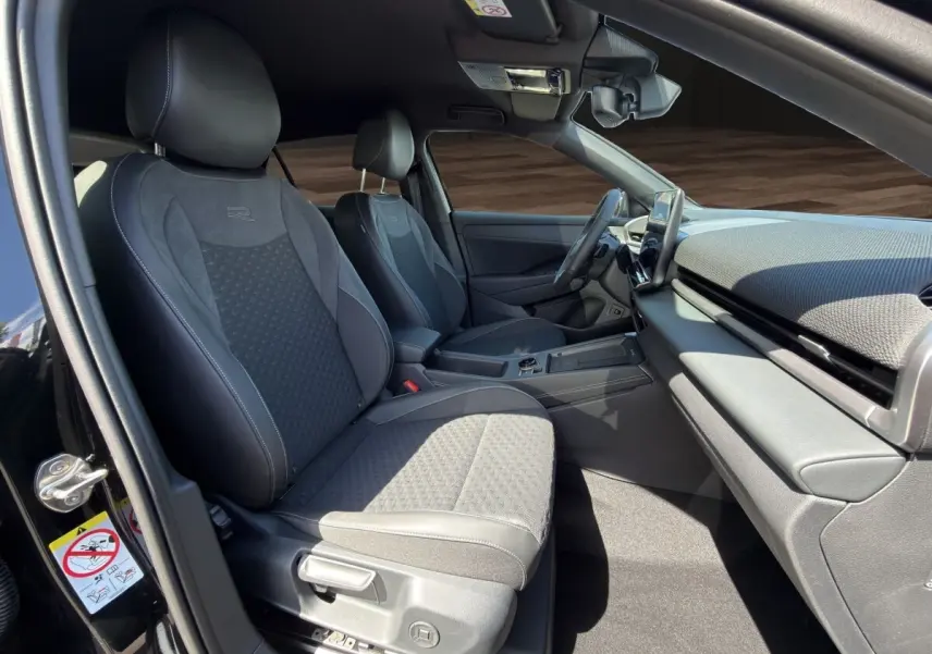 Vue intérieure côté conducteur du Volkswagen T-Roc noir 2026, mettant en valeur les sièges sport R et le tableau de bord moderne.