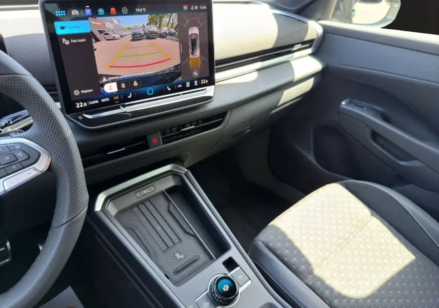 Vue intérieure côté passager du Volkswagen T-Roc noir 2026, avec écran tactile central affichant l'aide au stationnement.