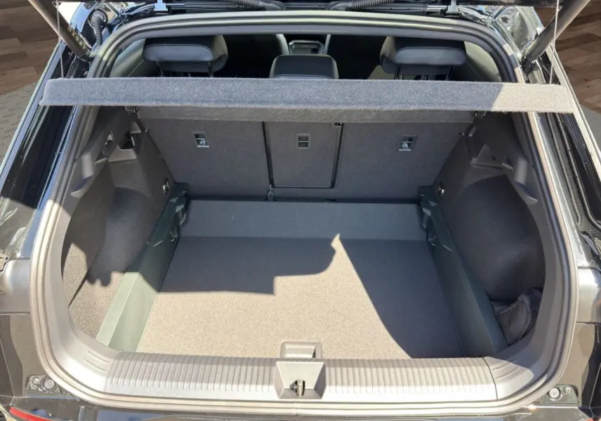 Vue arrière du coffre ouvert d'un Volkswagen T-Roc noir 2026, montrant l'espace de chargement et la tablette cache-bagages.
