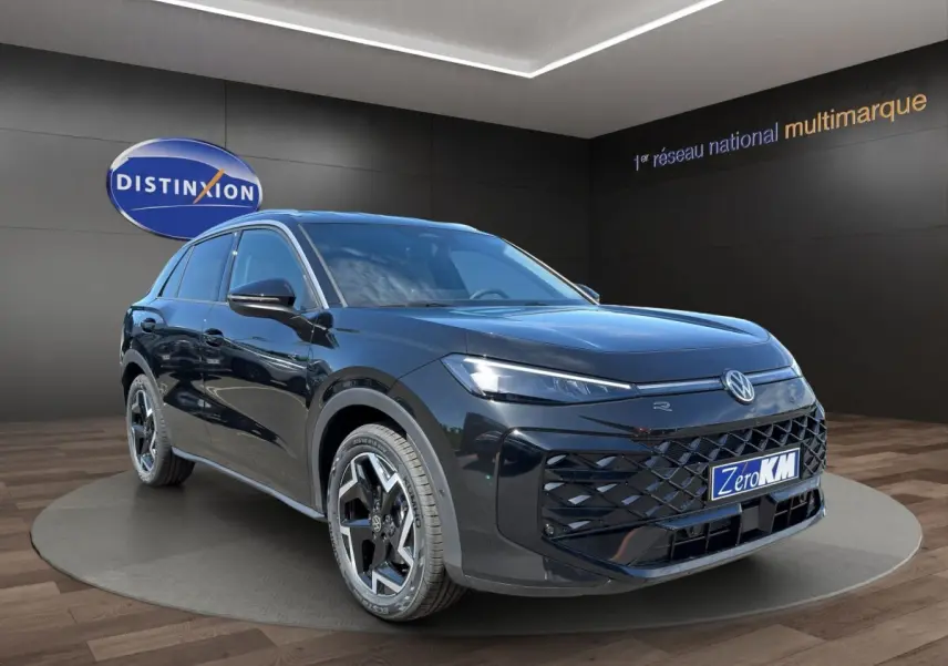 Volkswagen T-Roc noir en 3/4 avant droit avec calandre R-Line et jantes distinctives sur podium showroom.