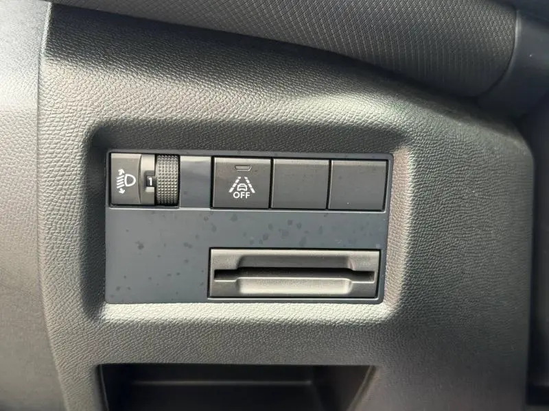 Détail intérieur côté gauche du tableau de bord noir du Citroën C5 Aircross 2024 avec commandes d'éclairage et assistance à la conduite.