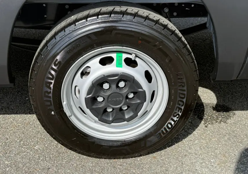 Gros plan sur la roue avant droite d’un Iveco Daily blanc, pneu Bridgestone et jante acier grise.