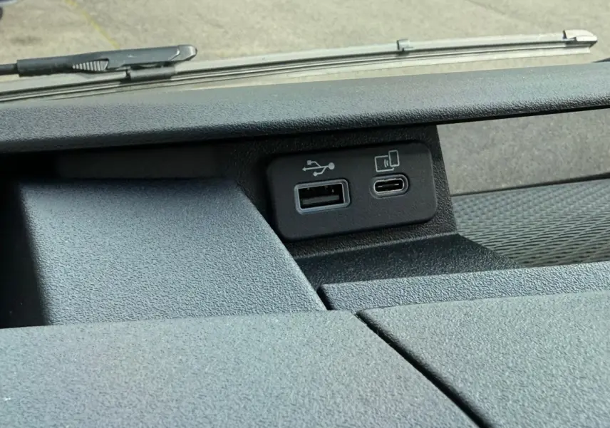 Gros plan sur les ports USB A et USB-C du tableau de bord du Iveco Daily blanc 2026, vue intérieure avant.