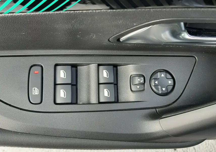 Panneau de commandes des vitres et rétroviseurs côté conducteur du Peugeot 2008 gris, intérieur noir.