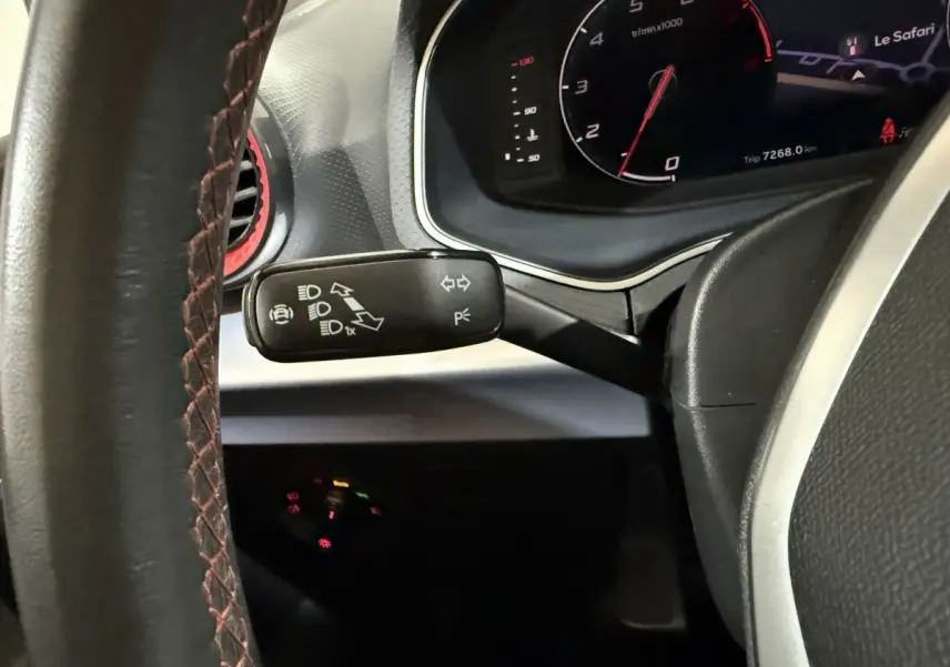 Vue rapprochée du volant cuir noir avec surpiqûres rouges et du commodo de clignotants d'une SEAT Ibiza 1.0 TSI 110 FR 2024.