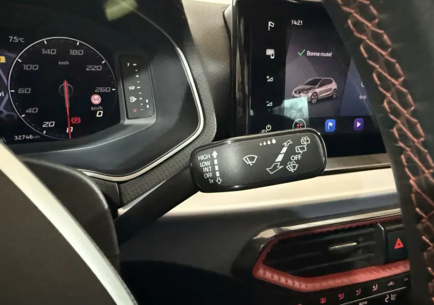 Vue intérieure rapprochée du tableau de bord noir de la SEAT Ibiza 1.0 TSI 110 FR avec volant cuir et écran tactile.