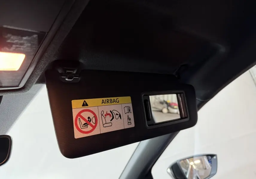 Détail du pare-soleil côté conducteur avec miroir et avertissement airbag dans une SEAT Ibiza noire 2024.