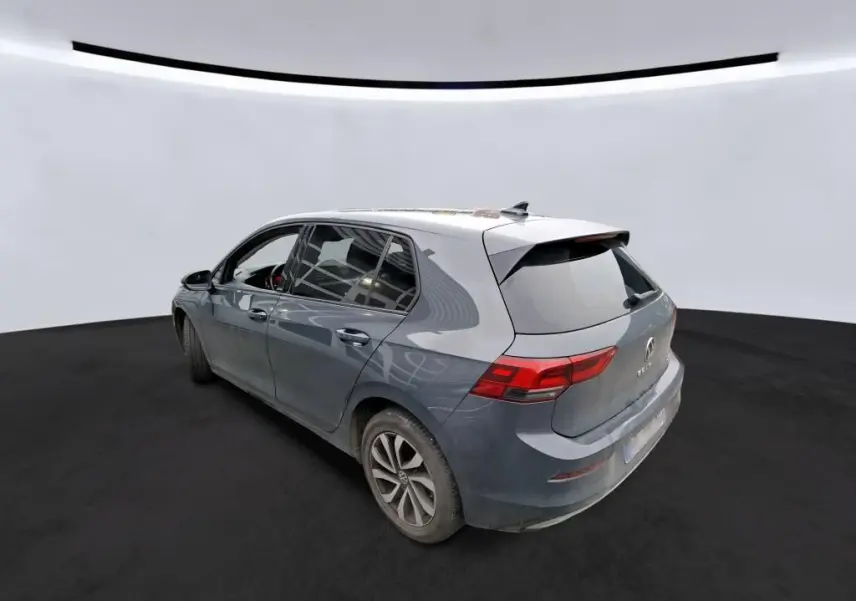 Volkswagen Golf gris vue 3/4 arrière droit, compacte cinq portes avec feux arrière LED et jantes alliage.