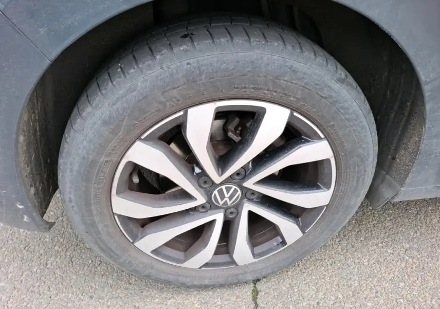 Gros plan sur la roue avant gauche de la Volkswagen Golf gris 1.5 eTSI 130 DSG7 avec jante alliage distinctive.