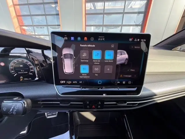 Vue rapprochée de l’écran tactile central et du tableau de bord numérique de la Volkswagen Golf blanche 2025, intérieur moderne et épuré.
