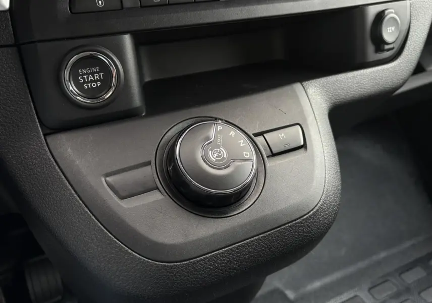 Gros plan sur la molette de boîte automatique et bouton start/stop dans l'habitacle noir de l'Opel Zafira Life XL 2024.