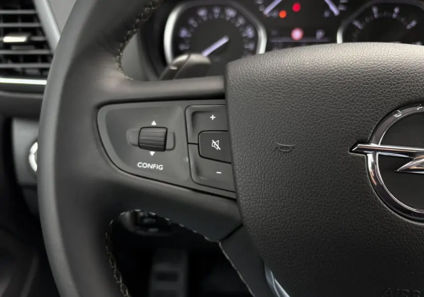 Gros plan sur le volant en cuir noir d'une Opel Zafira Life XL avec commandes intégrées et logo Opel visible.