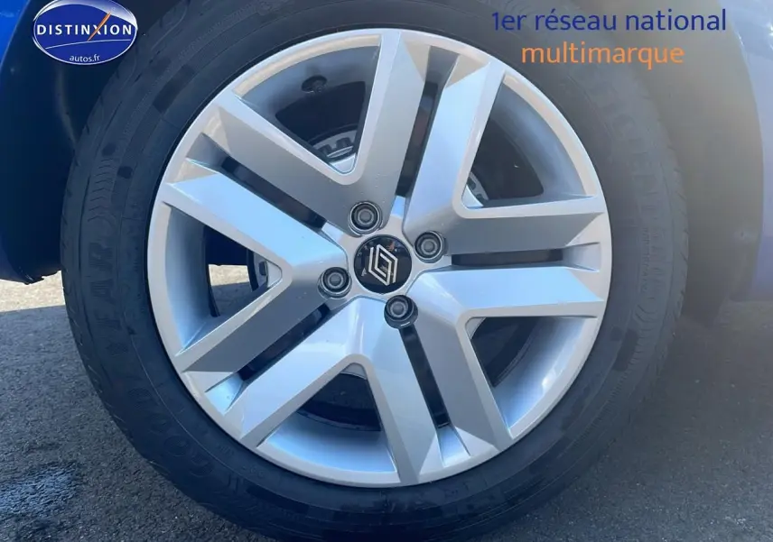 Gros plan sur la jante argentée de la Renault Clio V bleu iron, mettant en valeur le logo central et le pneu Goodyear.