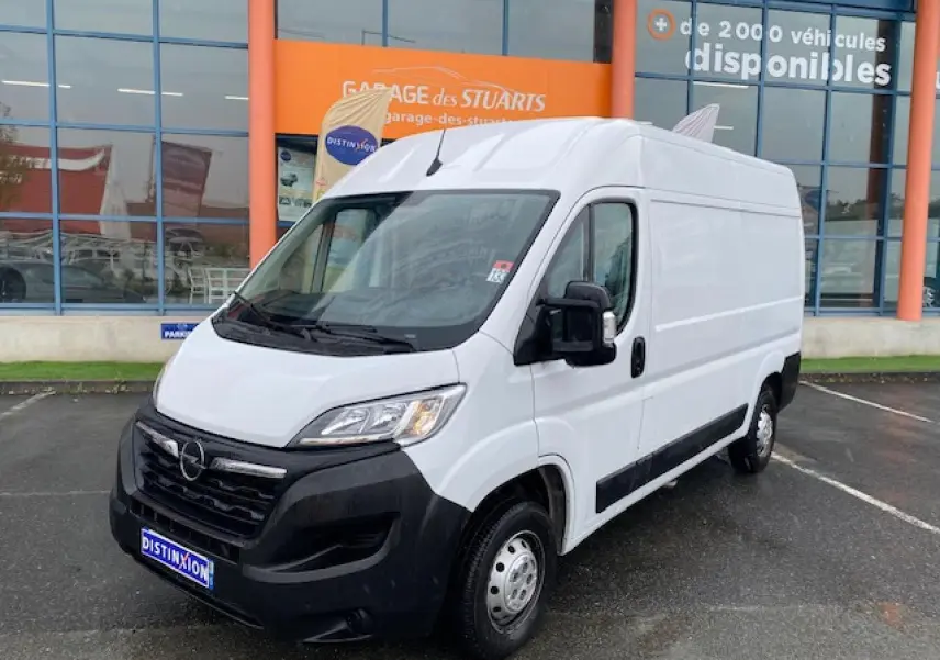 Opel Movano Fourgon blanc vu en 3/4 avant droit, avec calandre noire et rétroviseurs électriques dégivrants.