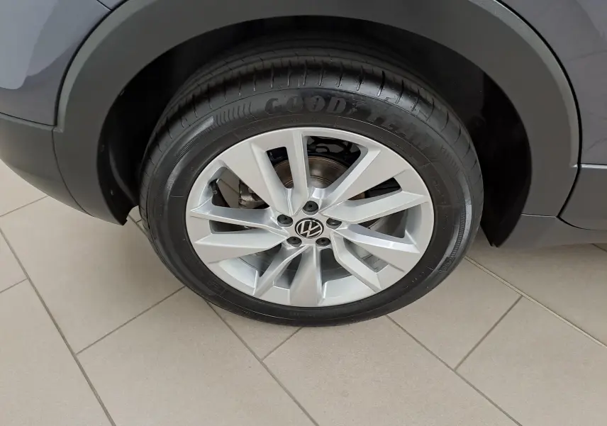 Gros plan sur la roue avant droite du Volkswagen T-Cross gris cendré avec jante alliage et pneu Goodyear.