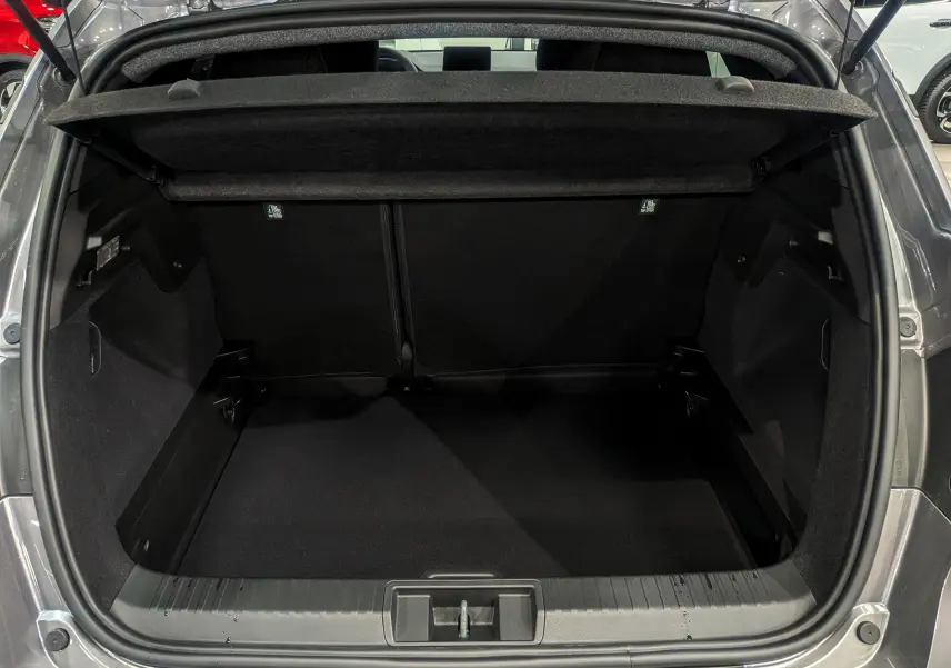 Coffre ouvert d'un Renault Captur Gris Cassiopé 2025, vue arrière montrant l'espace de chargement vide et la tablette cache-bagages.