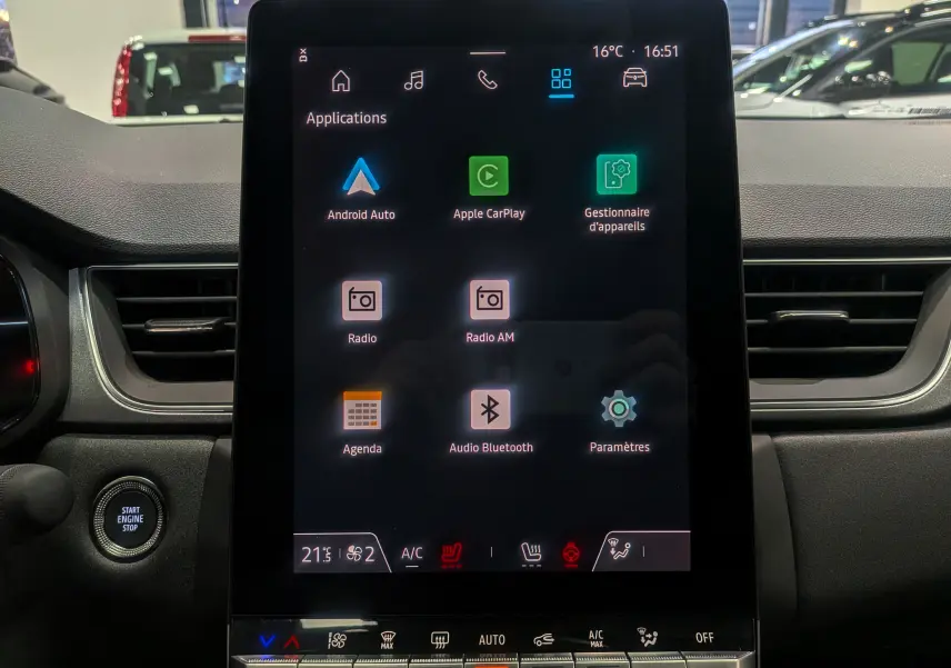 Écran tactile central allumé du Renault Captur Gris Cassiopé, vue frontale de l'habitacle avec commandes climatisation visibles.