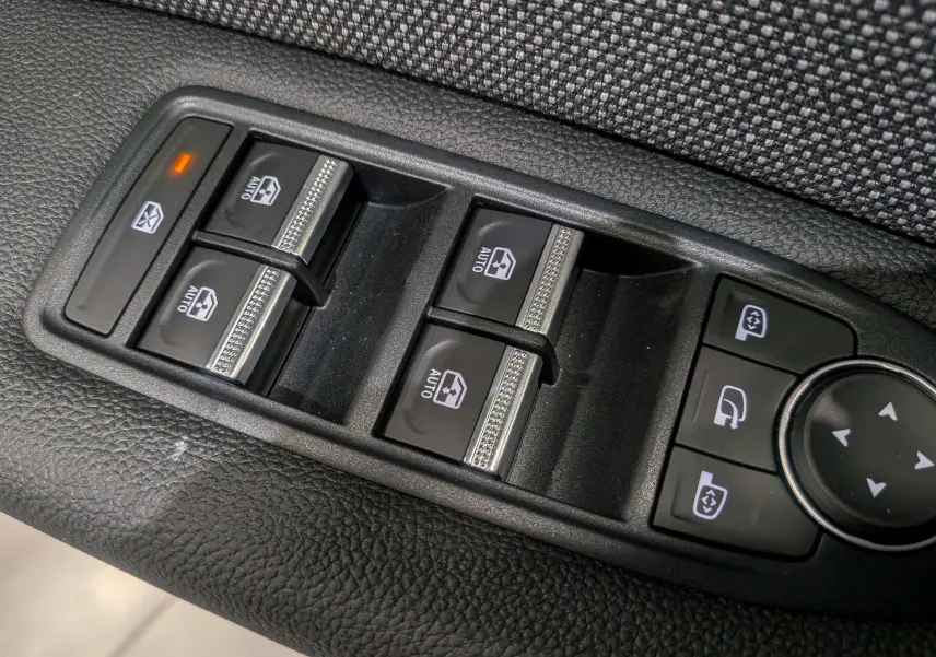 Gros plan sur les commandes de lève-vitres et réglage des rétroviseurs du Renault Captur gris Cassiopé 2025.