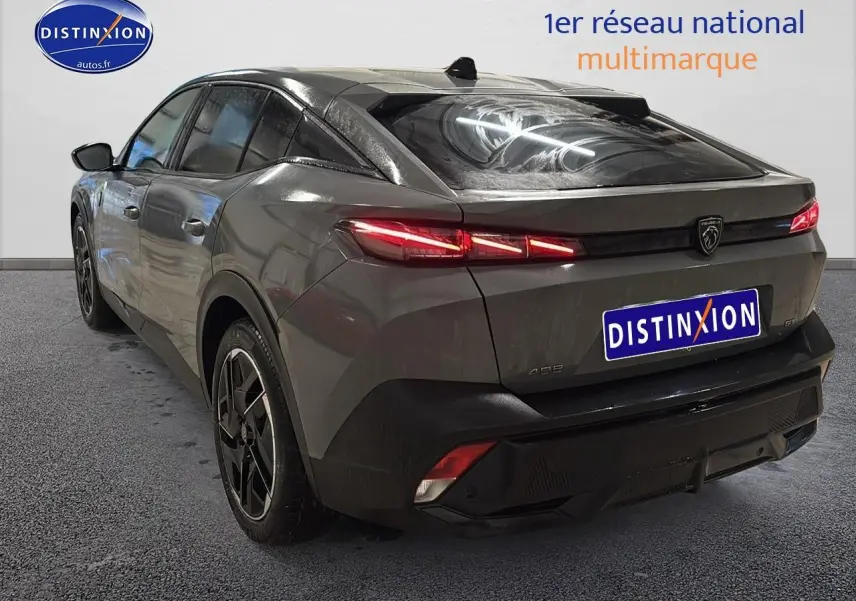 Vue 3/4 arrière droite d'une Peugeot 408 Hybrid 145 GT gris sélénite avec feux arrière LED allumés et jantes alu noires.