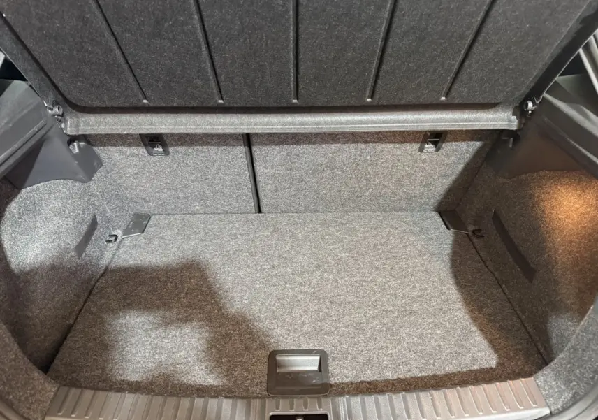 Coffre ouvert vu de face, intérieur gris avec revêtement tissu, espace de rangement propre et bien éclairé.