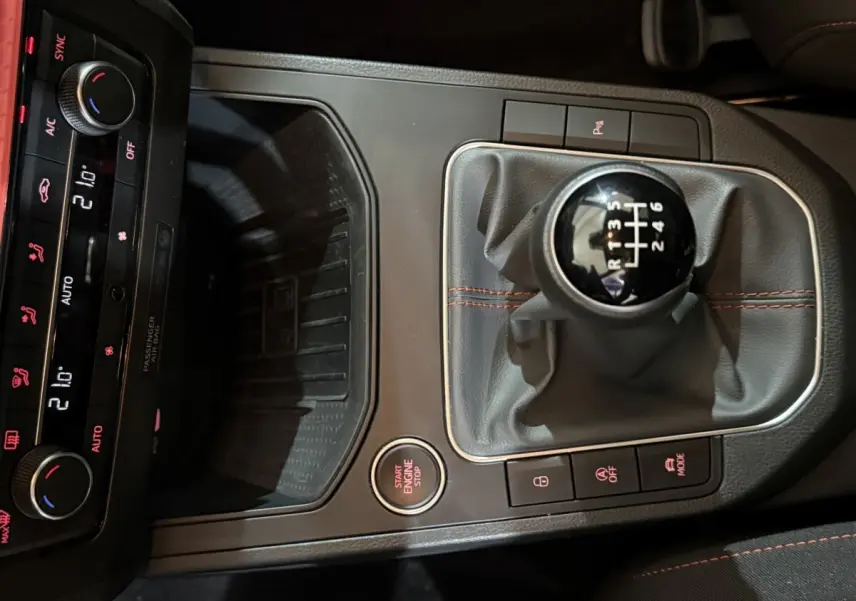 Vue rapprochée de la console centrale noire de la SEAT Ibiza 1.0 TSI 110 FR 2024, avec levier de vitesses manuel et bouton start/stop.