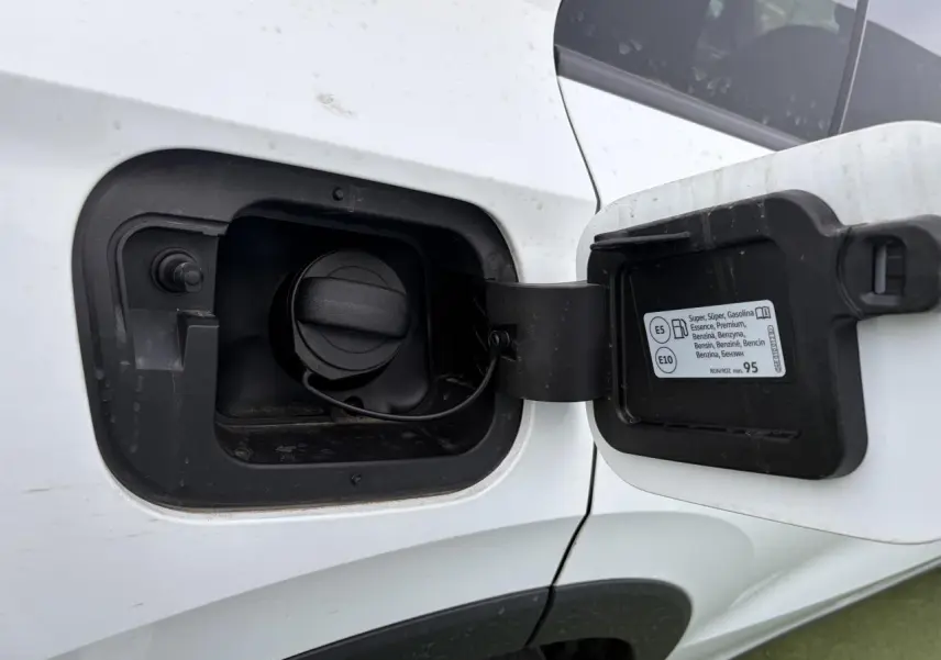 Gros plan sur la trappe à carburant côté gauche d'un Volkswagen T-Roc blanc pur avec toit noir, essence, 2026.