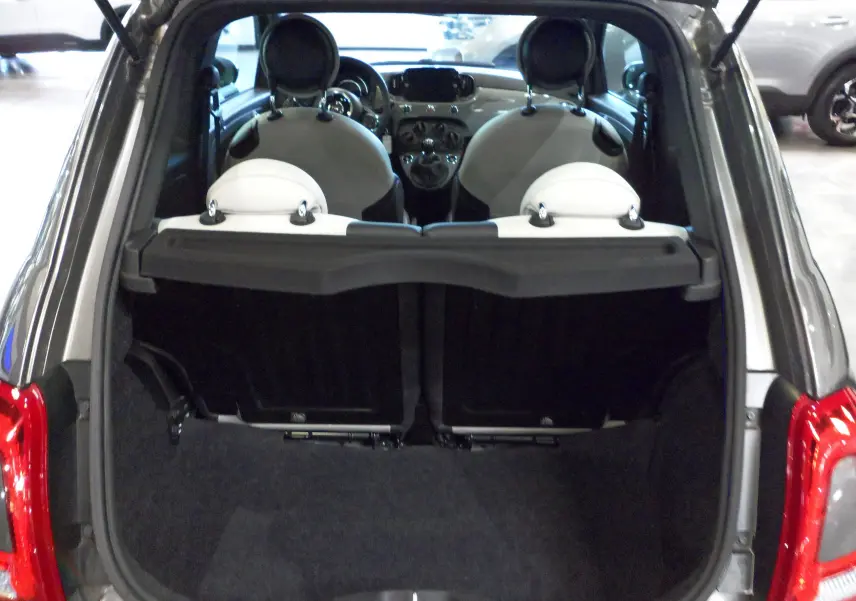 Vue arrière du coffre ouvert d'une FIAT 500 Electroclash Grey, montrant l'intérieur clair et les sièges avant.