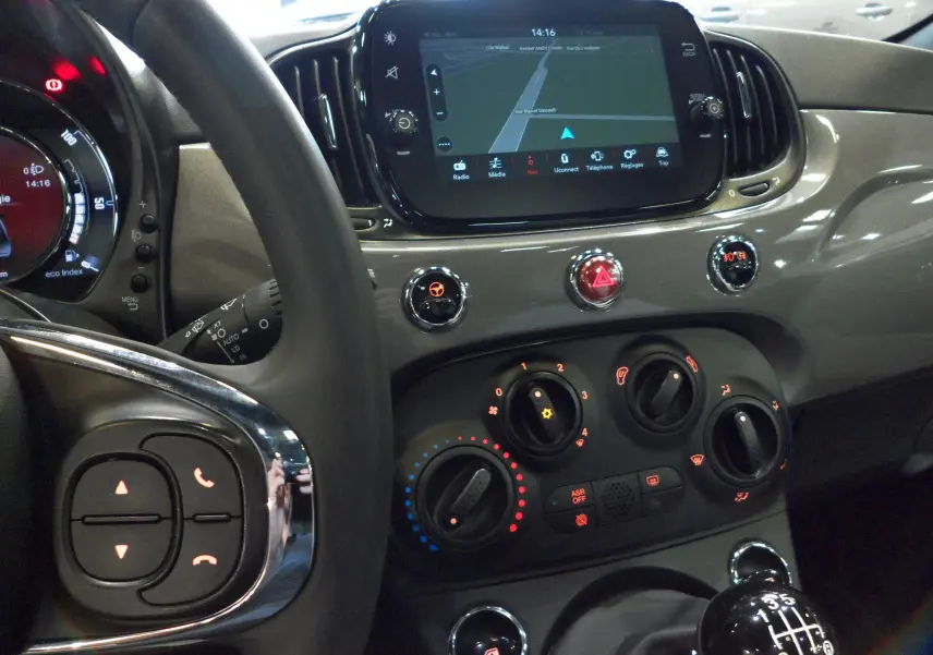 Intérieur de la Fiat 500 Electroclash Grey, vue du tableau de bord avec écran tactile et levier de vitesses manuel.