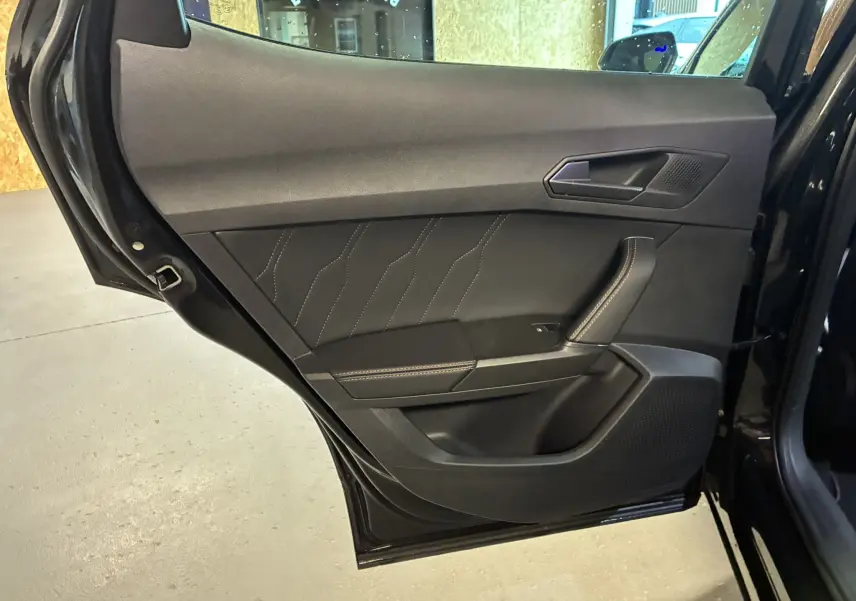 Vue rapprochée de la porte arrière gauche noire du CUPRA Formentor 1.4 E-HYBRID 2023 avec surpiqûres contrastées.