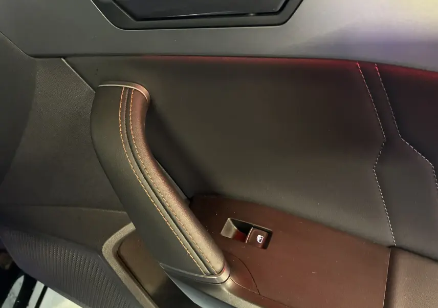 Détail de la poignée de porte intérieure côté gauche en cuir noir avec surpiqûres contrastantes sur CUPRA Formentor 2023.