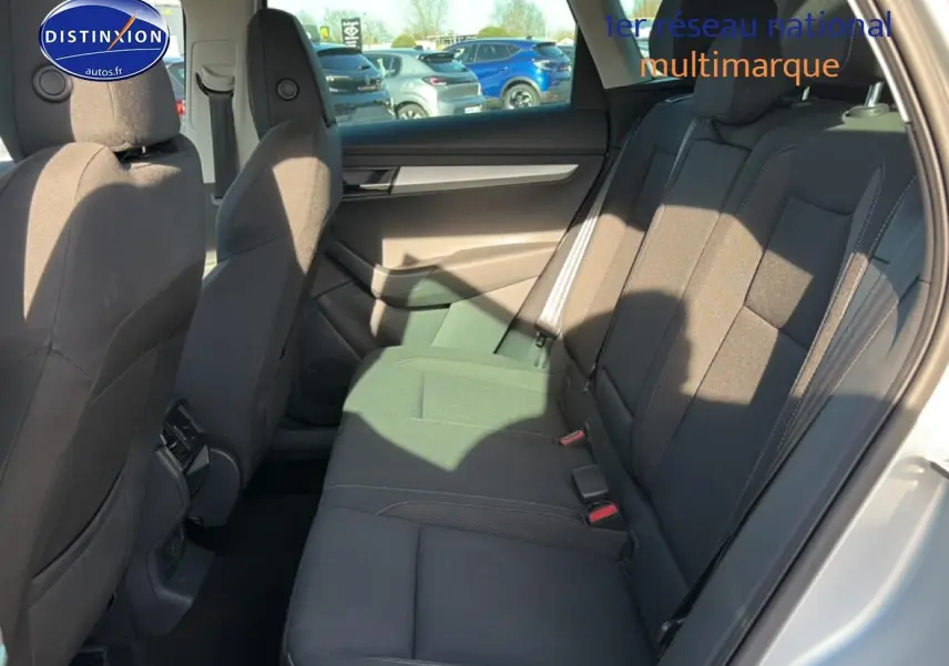 Vue intérieure côté droit sur la banquette arrière noire du Skoda Karoq gris avec appuie-têtes et ceintures visibles.