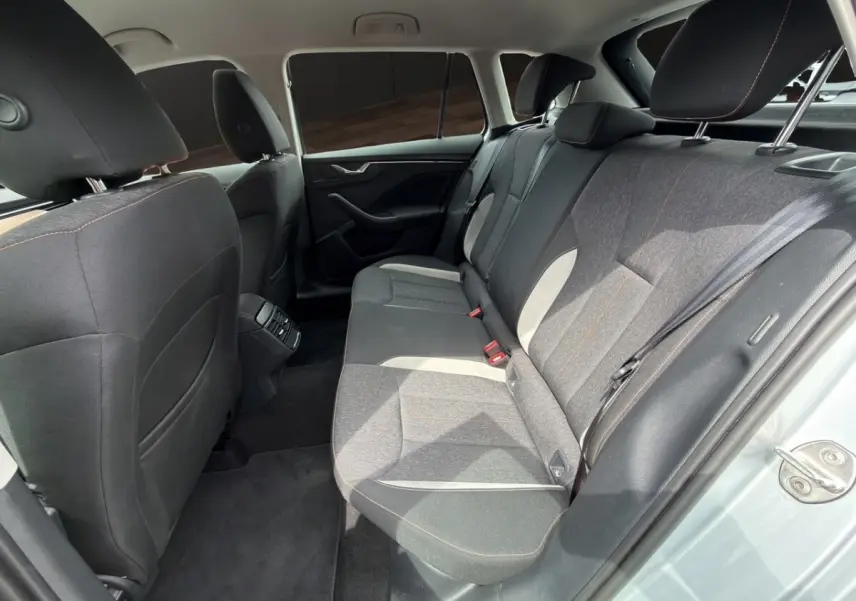 Vue intérieure côté droit des sièges arrière gris foncé avec surpiqûres orange du Skoda Kamiq gris clair 2023.