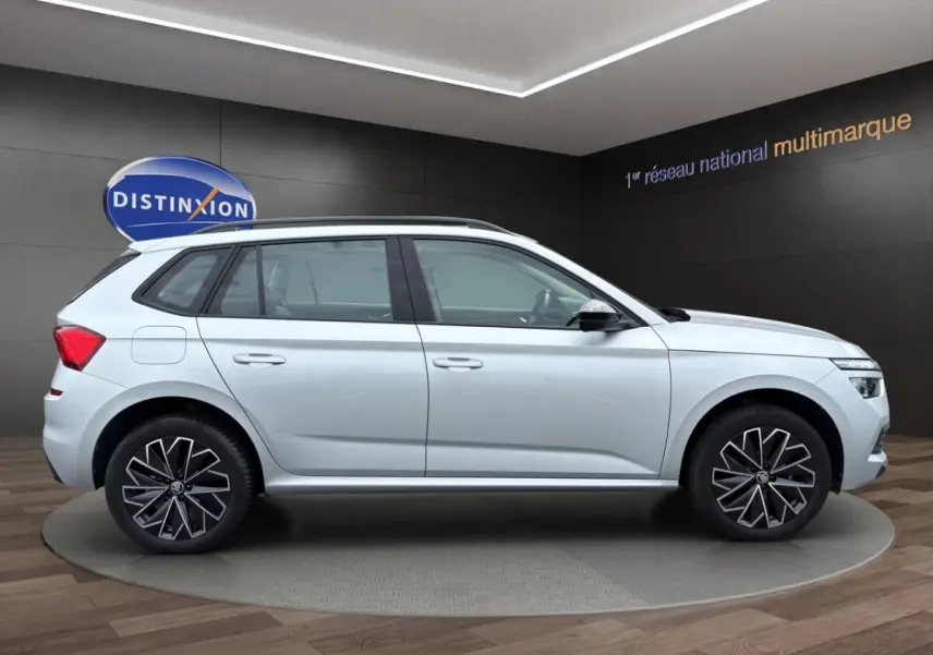 Vue latérale droite du Skoda Kamiq gris clair 2023 avec jantes bi-ton et rétroviseurs rabattables électriquement.