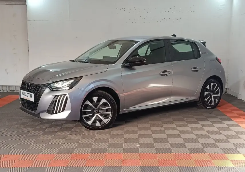 Peugeot 208 Hybrid gris clair vue 3/4 avant droit, avec jantes stylisées et feux LED distinctifs.