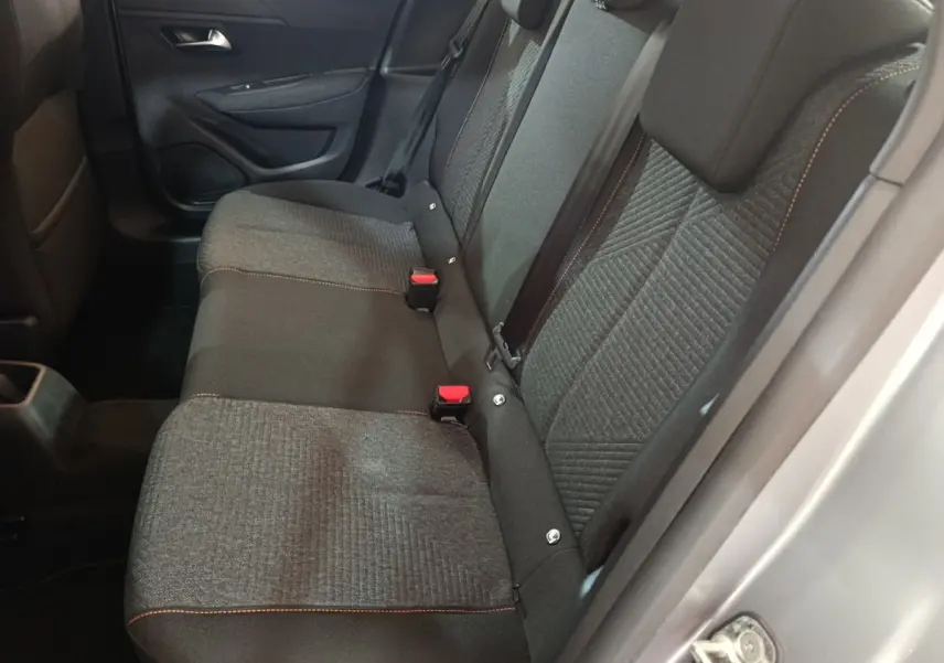 Vue côté droit de la banquette arrière grise avec surpiqûres orange dans une Peugeot 208 Hybrid 2025.