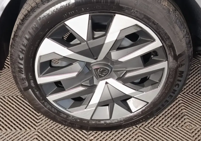 Gros plan sur la jante alliage bicolore gris et argent avec logo Peugeot au centre, montée sur pneu Michelin.