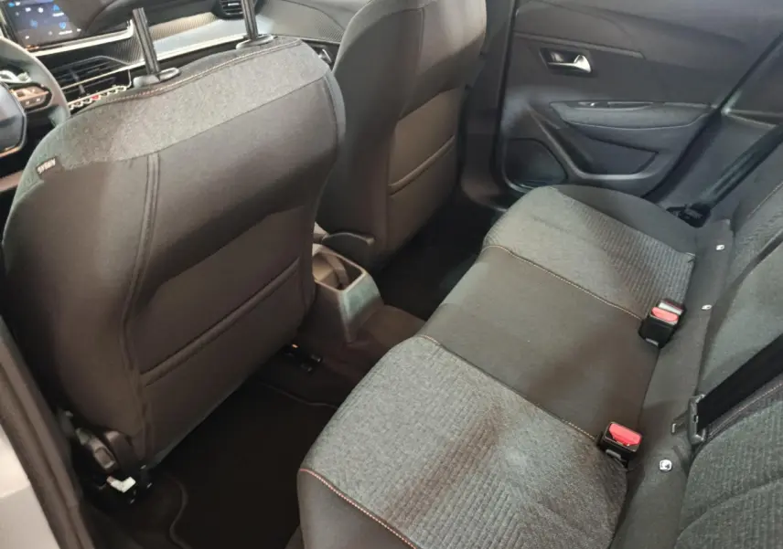 Vue intérieure arrière droite de la banquette tissu gris foncé et clair de la Peugeot 208 Hybrid 2025.