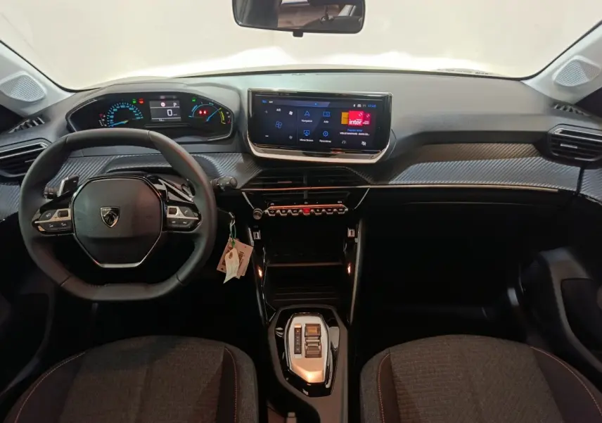 Vue intérieure frontale du tableau de bord et volant cuir noir de la Peugeot 208 Hybrid 100 e-DCS6 Style 2025.