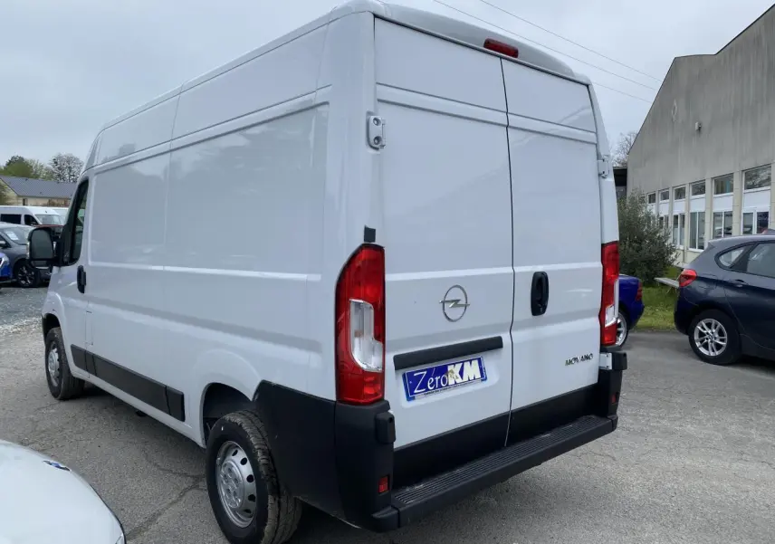 Vue 3/4 arrière droite d'un fourgon Opel Movano blanc avec portes arrière battantes et pare-chocs noir.