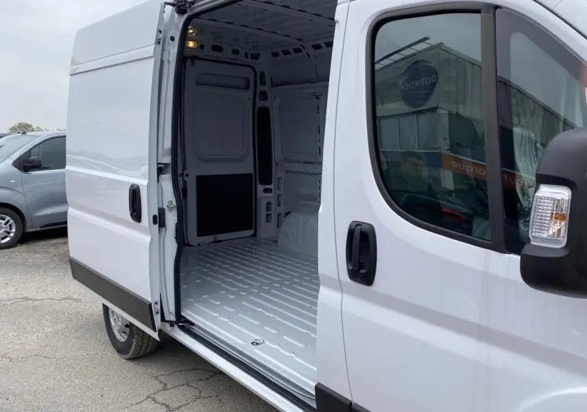 Vue latérale droite d’un Opel Movano Fourgon blanc 2022 avec porte coulissante ouverte montrant l’intérieur vide tôlé.